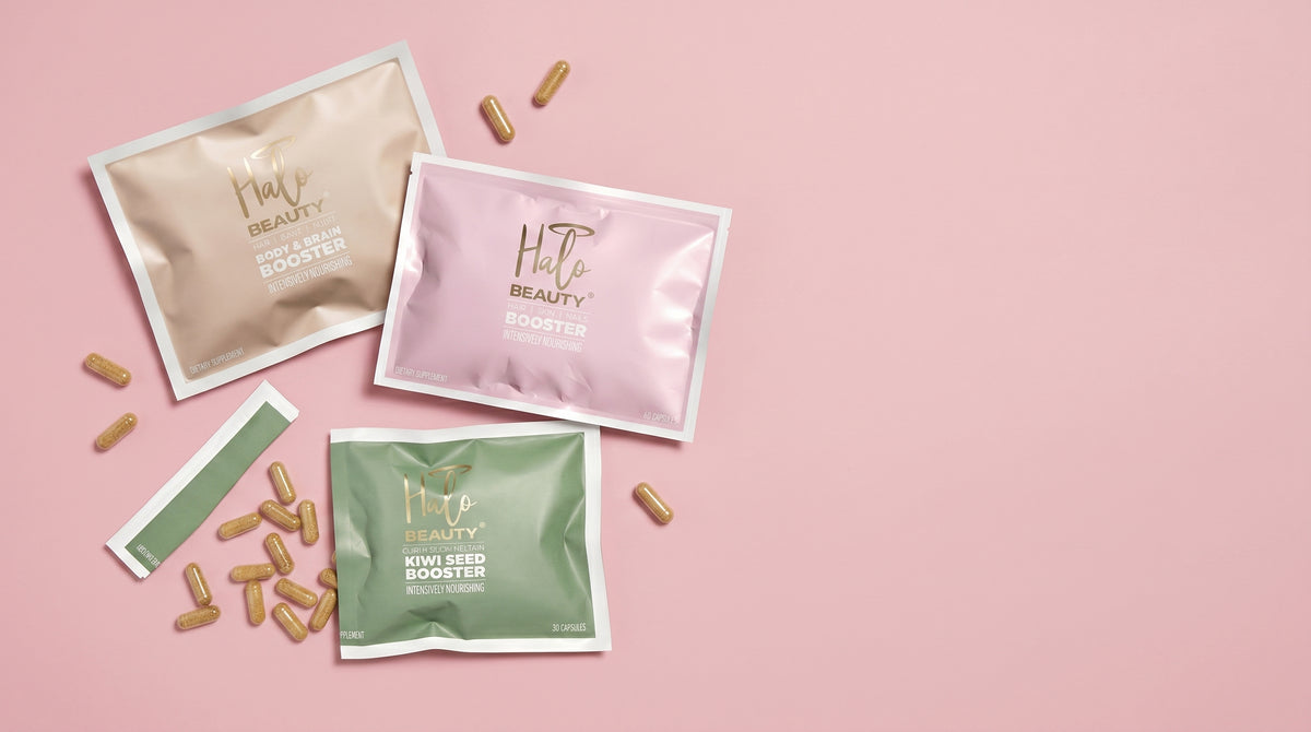 Three packets of 'Her Beauty' on a pink background with scattered capsules.